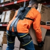 Egzoszkielet pasywny Apex HeroWear – pracownik w magazynie podnoszący ciężkie pudełko z założonym systemem.