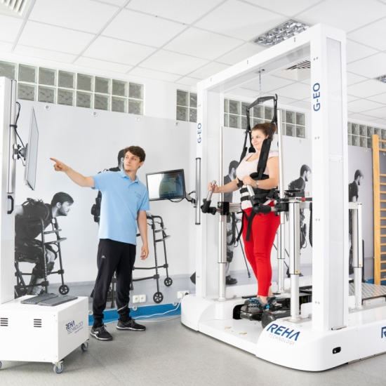 G-EOs – system do reedukacji chodu, pacjentka podczas terapii z asekuracją terapeuty.