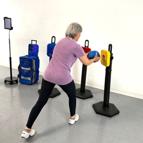 SMARTfit Neuro Rehab Kit – senior wykonuje ćwiczenia reakcji i równowagi z piłką lekarską.