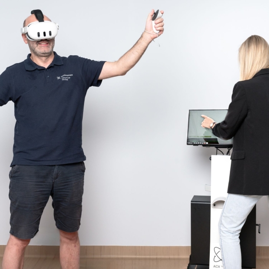 Pacjent wykonuje ćwiczenia w goglach VR X-Visio Pro pod nadzorem terapeuty.