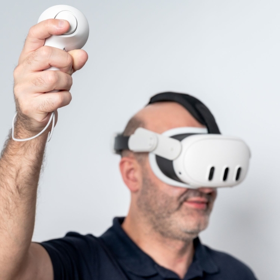 Zbliżenie na pacjenta korzystającego z kontrolera i gogli VR X-Visio Pro.
